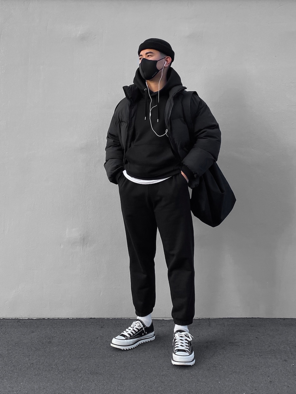 ブラック系のスウェットパンツ、ブラック系のダウンジャケット/コート、ブラック系のパーカーを着用したメンズの冬コーディネートの1枚目の写真