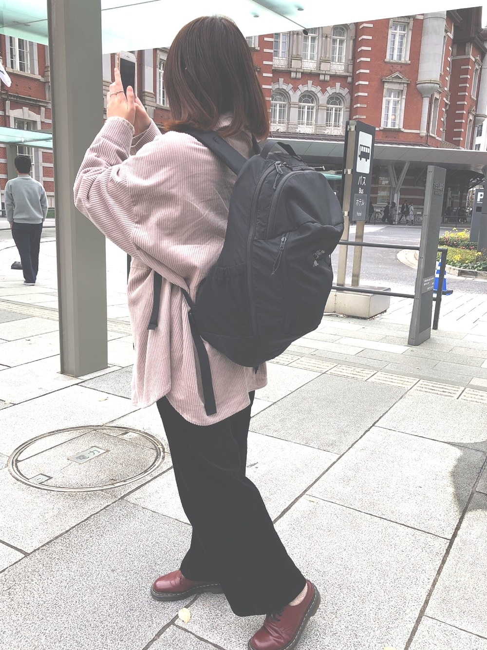 ブラック系のバックパック/リュック、レッド系のドレスシューズ、ピンク系のジャケット/アウターを着用したレディースの冬コーディネートの1枚目の写真