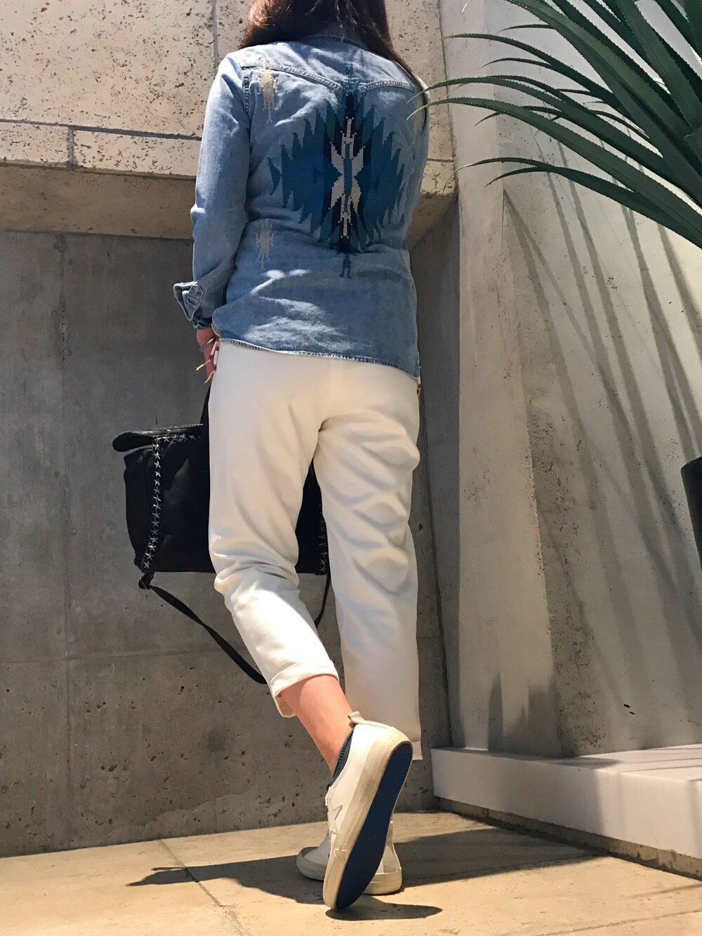 ホワイト系のパンツ、ブラック系のショルダーバッグ、ブルー系のシャツ/ブラウスを着用したレディースの春コーディネートの1枚目の写真