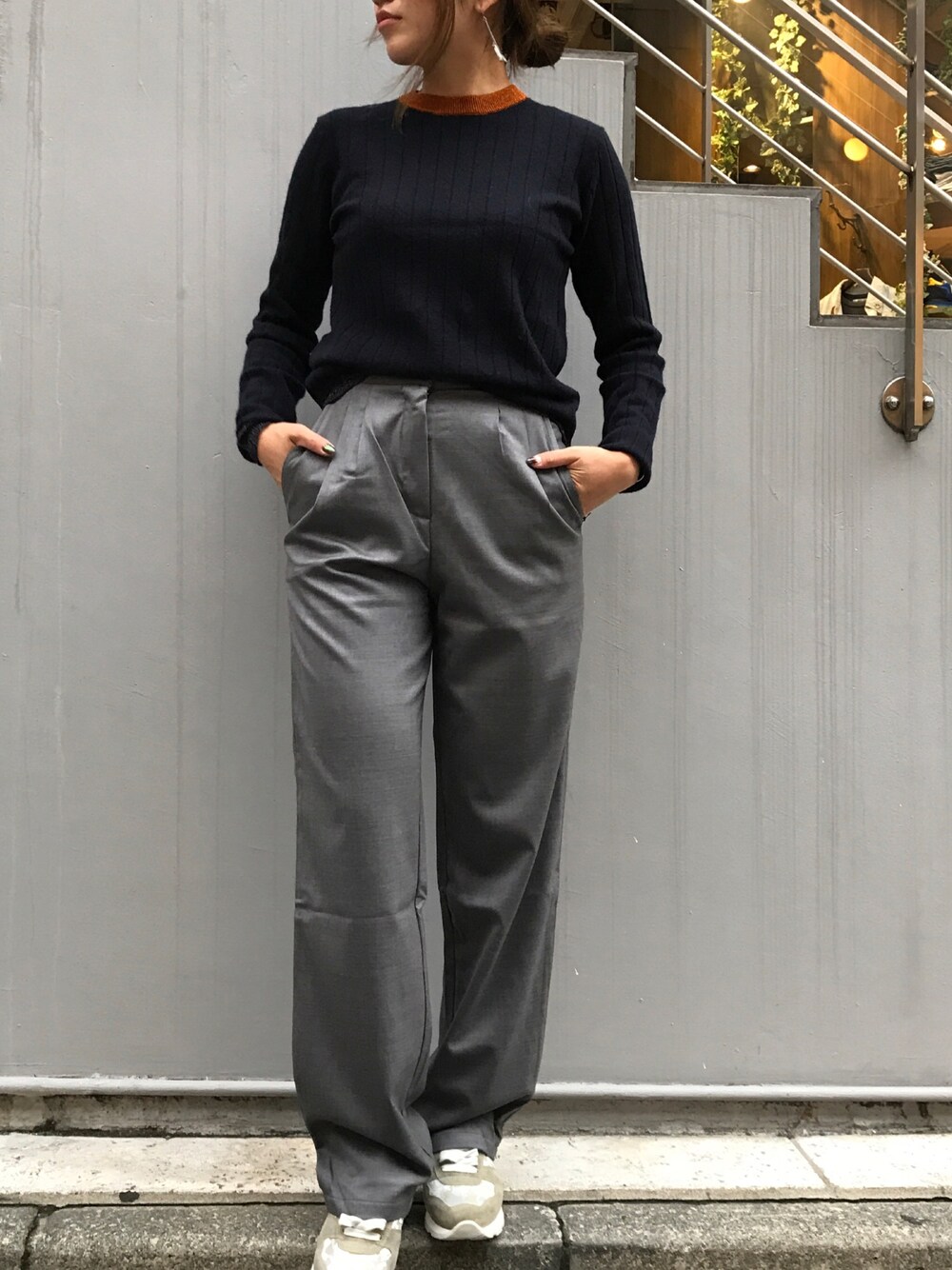 グレー系のパンツ、ブルー系のニット/セーター、グレー系のスニーカーを着用したレディースの秋コーディネートの1枚目の写真