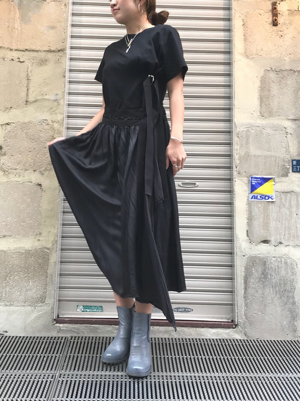 ブラック系のワンピース、グレー系のブーツ、シルバー系のピアス（両耳用）を着用したレディースの秋コーディネートの1枚目の写真