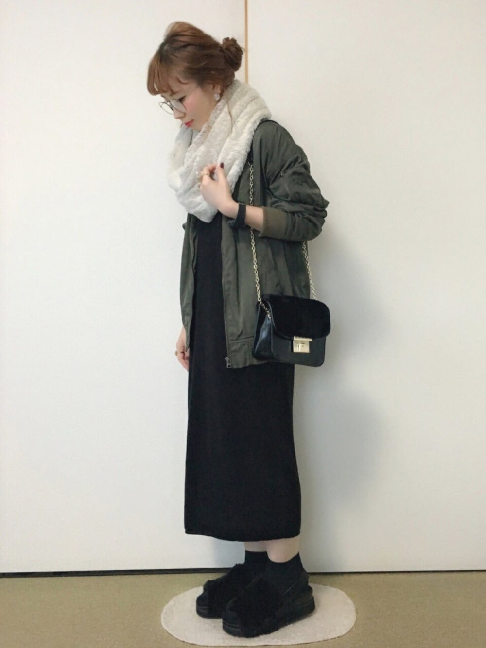 グリーン系のミリタリージャケット、ブラック系のワンピース、ブラック系のバッグを着用したレディースの冬コーディネートの1枚目の写真