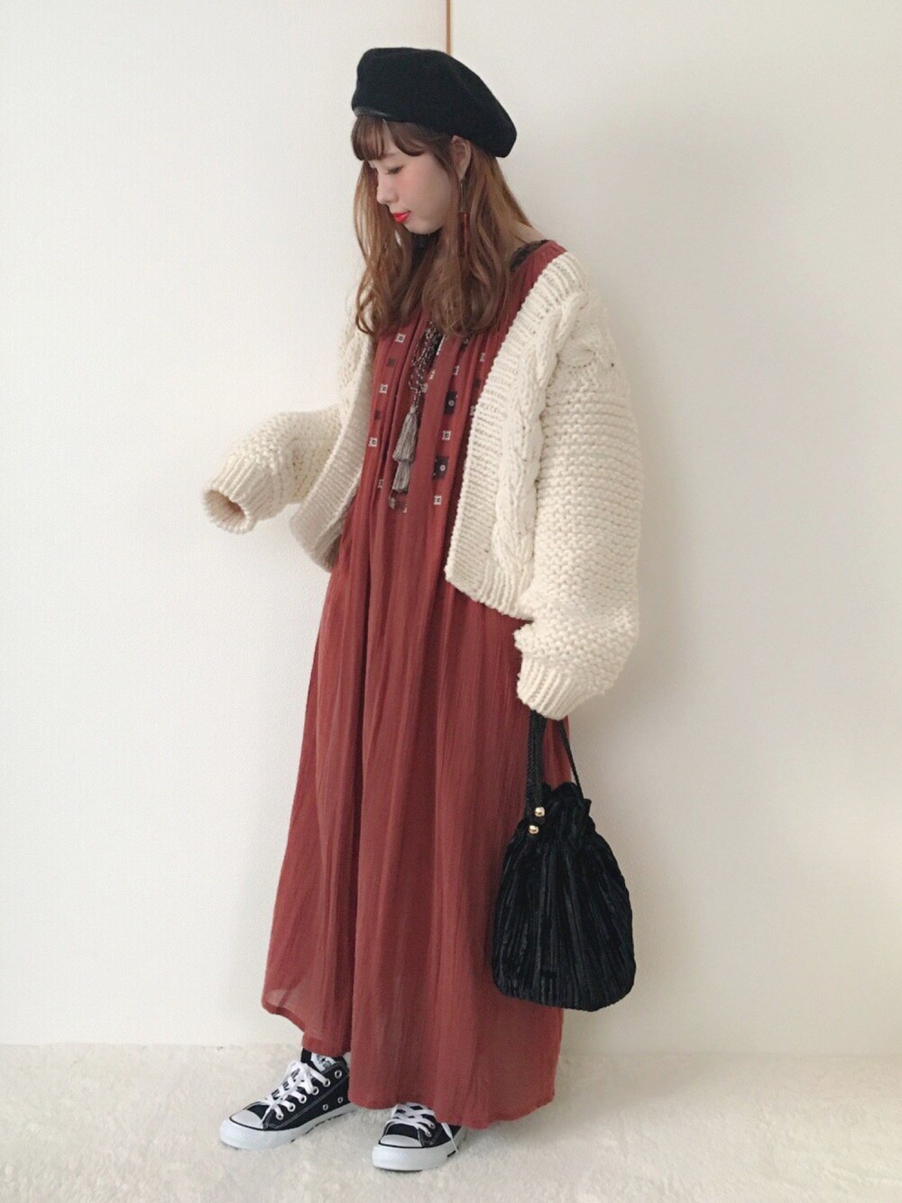 ホワイト系のカーディガン/ボレロ、レッド系のワンピース、ブラック系のハンドバッグを着用したレディースの秋コーディネートの1枚目の写真