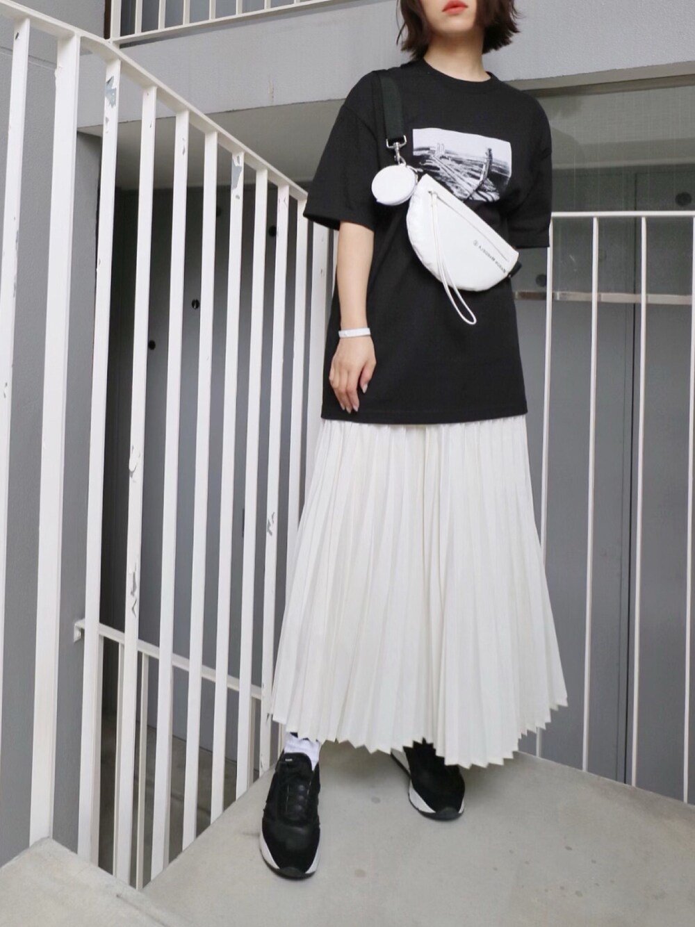 ブラック系のTシャツ/カットソー、ホワイト系のボディバッグ/ウエストポーチ、ホワイト系のバングル/リストバンドを着用したレディースの春コーディネートの1枚目の写真