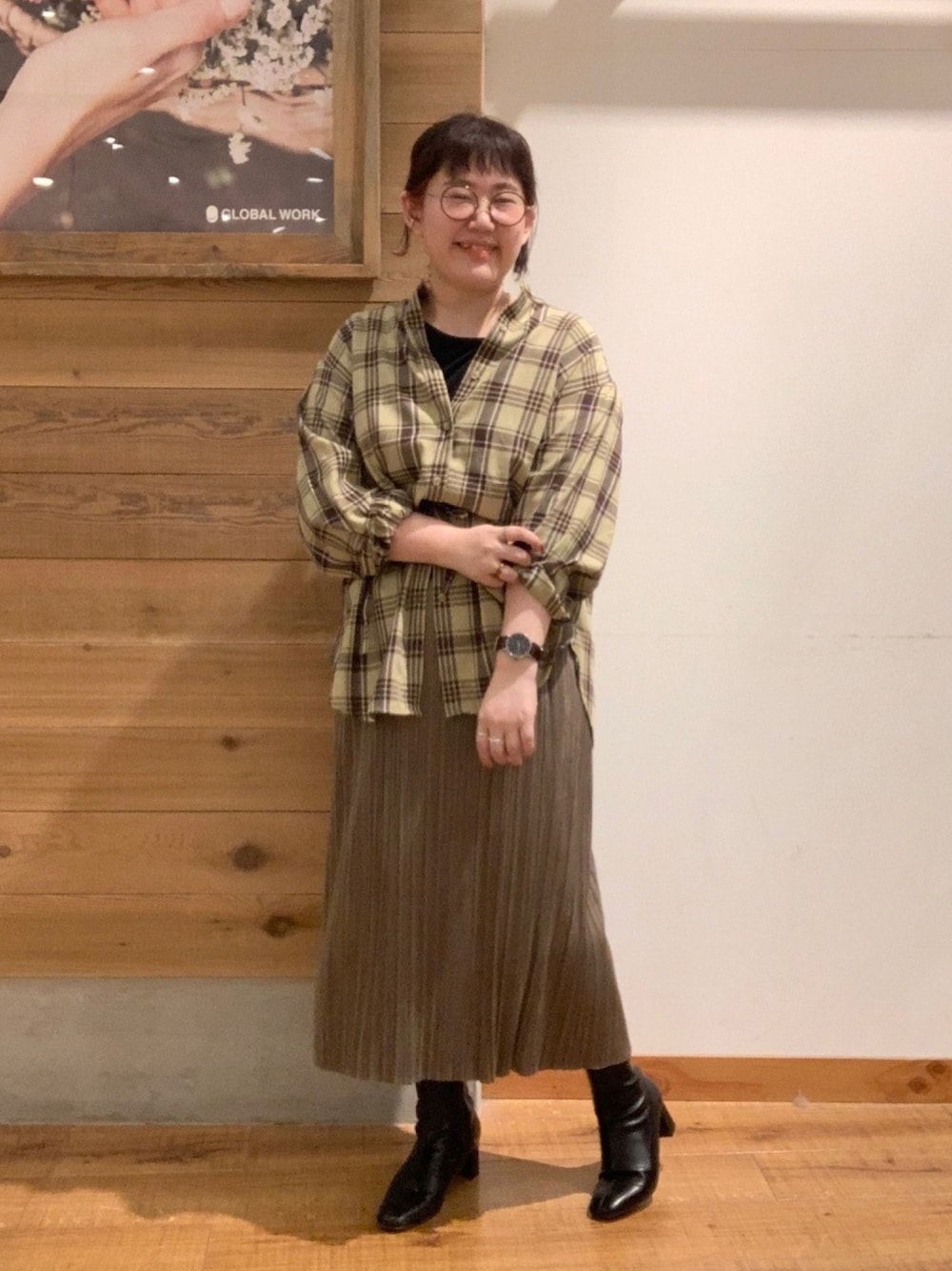 イエロー系のシャツ/ブラウス、ブラウン系のスカート、ブラック系のブーツを着用したレディースの秋コーディネートの1枚目の写真