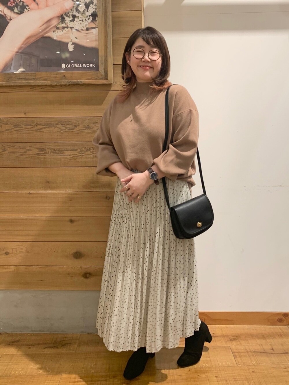 イエロー系のニット/セーター、ブラック系のショルダーバッグ、ホワイト系のスカートを着用したレディースの秋コーディネートの1枚目の写真