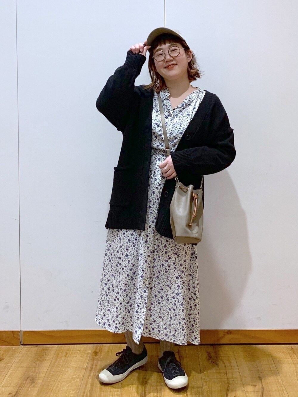 ホワイト系のワンピース、ブラック系のカーディガン/ボレロ、ベージュ系のショルダーバッグを着用したレディースの冬コーディネートの1枚目の写真