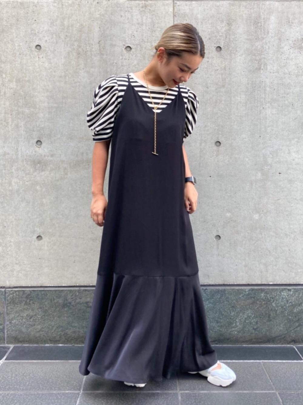 ブラック系のワンピース、ホワイト系のスニーカー、ゴールド系のネックレスを着用したレディースの夏コーディネートの1枚目の写真