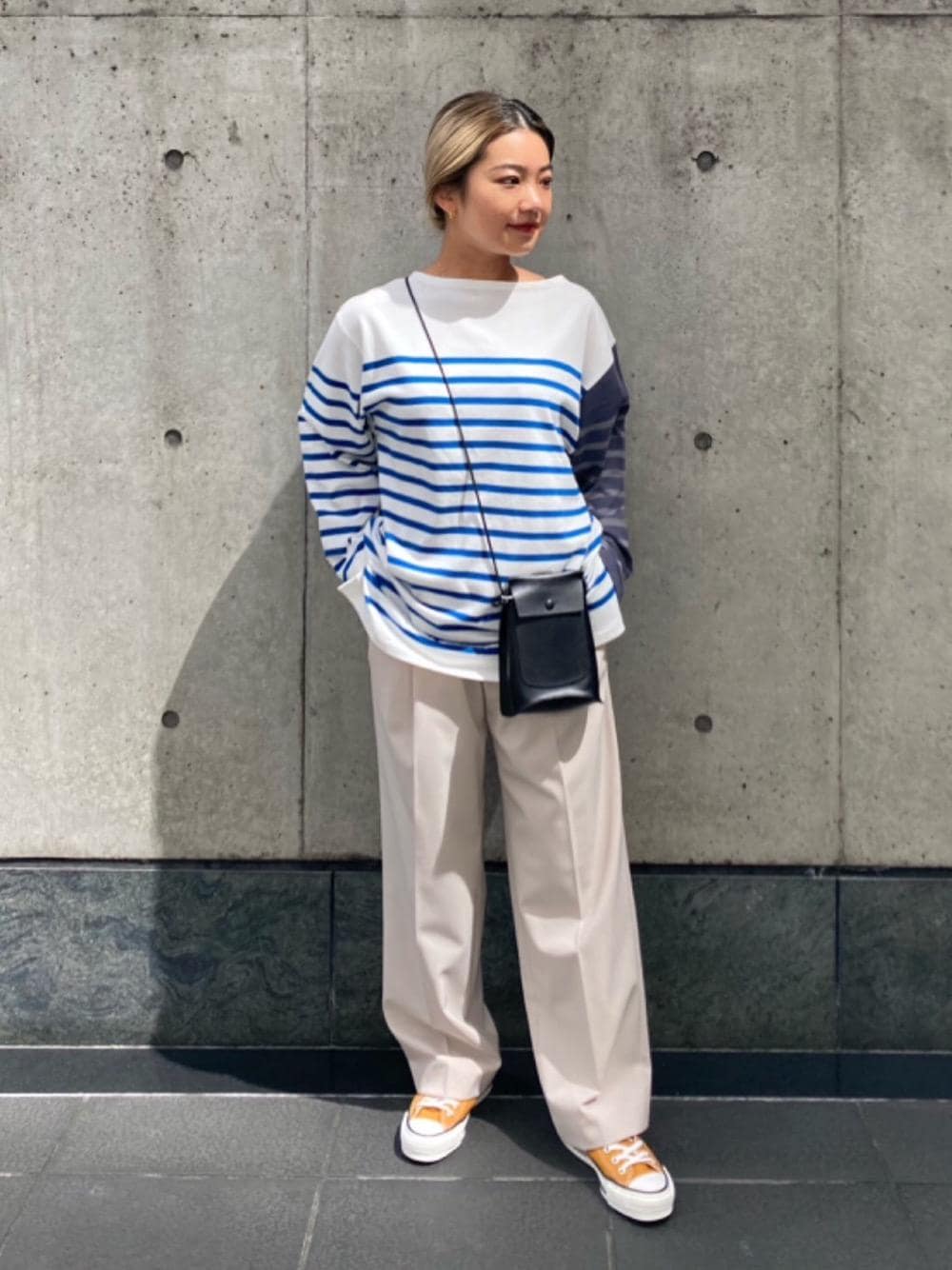 ブルー系のTシャツ/カットソー、ブラック系のショルダーバッグ、イエロー系のスニーカーを着用したレディースの夏コーディネートの1枚目の写真