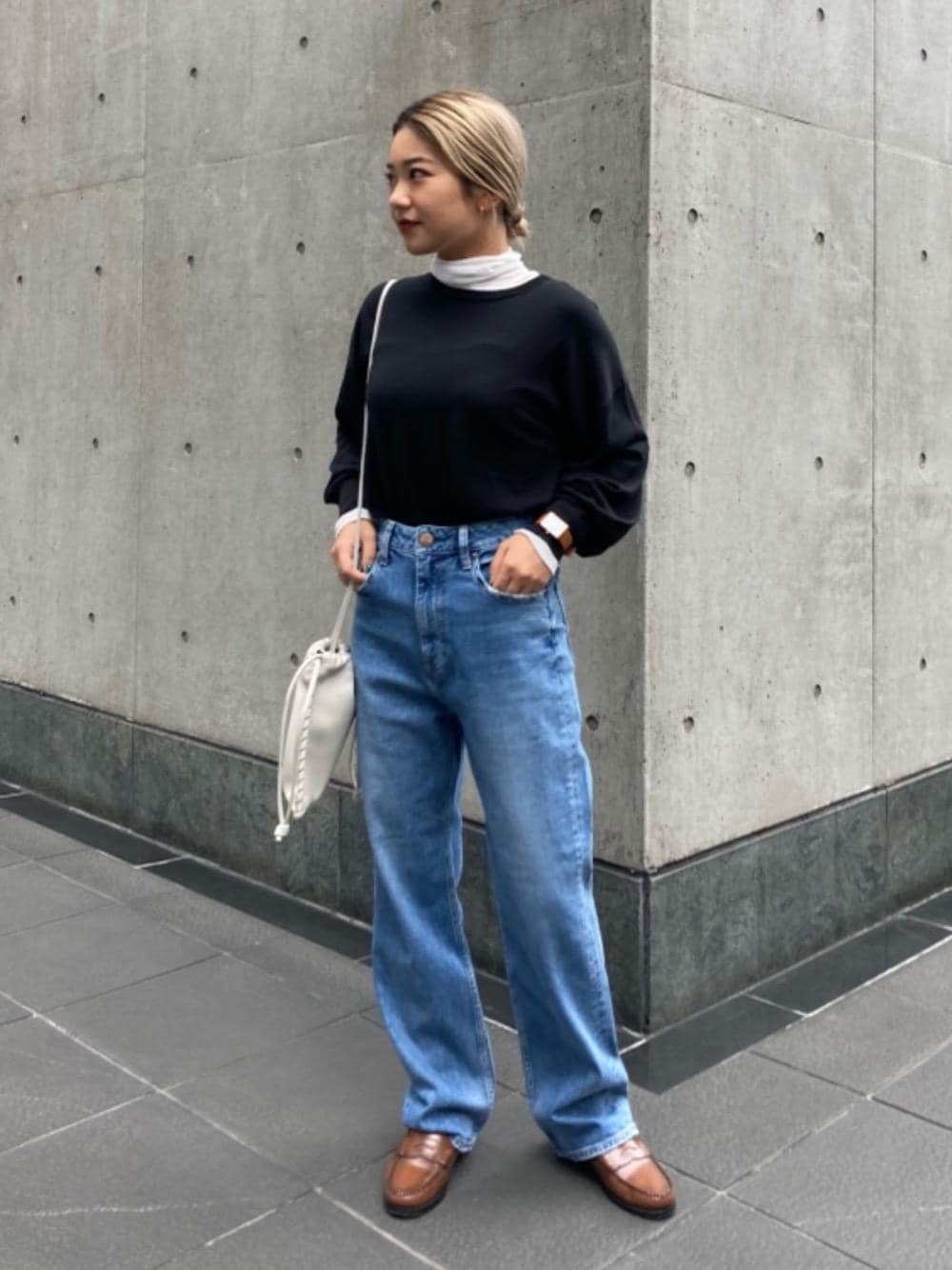 ブルー系のデニムパンツ、ホワイト系のTシャツ/カットソー、ブラック系のニット/セーターを着用したレディースの秋コーディネートの1枚目の写真