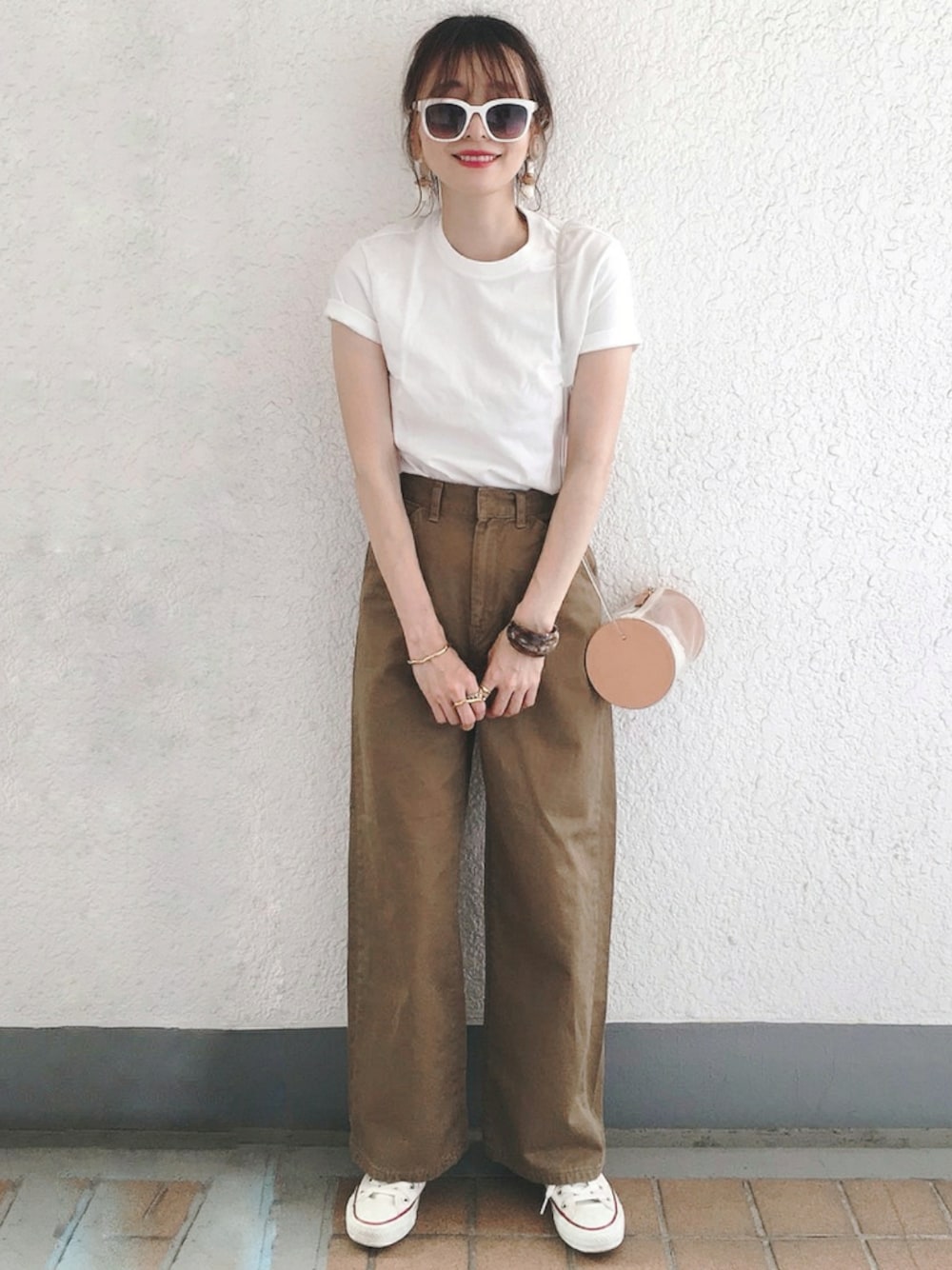 ホワイト系のTシャツ/カットソー、ブラウン系のチノパンツ、ホワイト系のスニーカーを着用したレディースの夏コーディネートの1枚目の写真