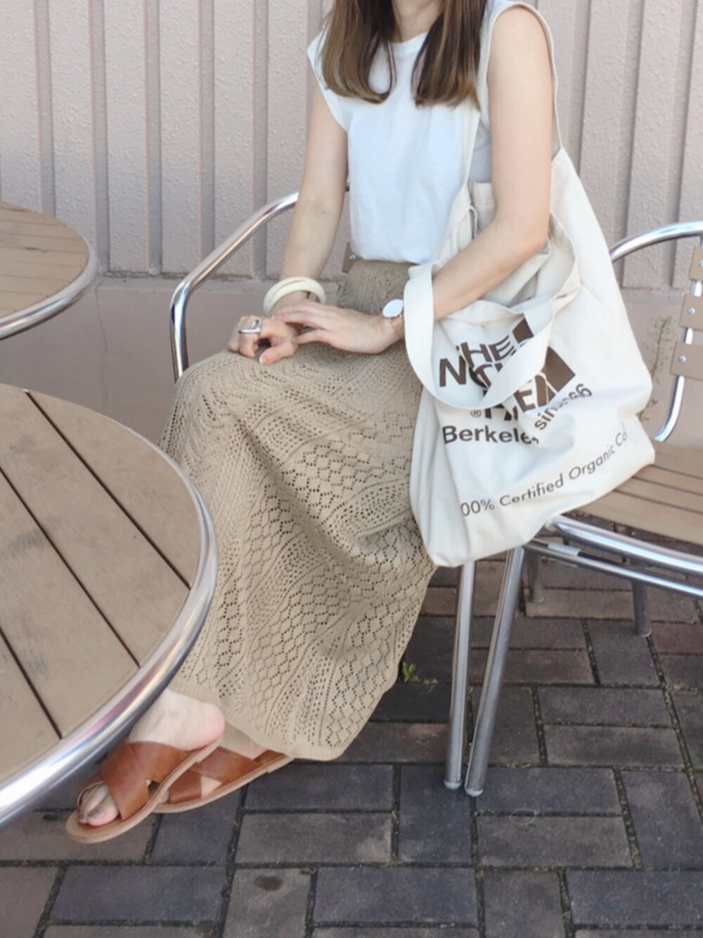 ホワイト系のタンクトップ、ベージュ系のスカート、ブラウン系のサンダルを着用したレディースの夏コーディネートの1枚目の写真