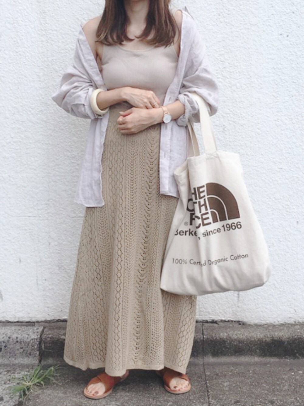 ベージュ系のタンクトップ、ベージュ系のスカート、ブラウン系のサンダルを着用したレディースの夏コーディネートの1枚目の写真