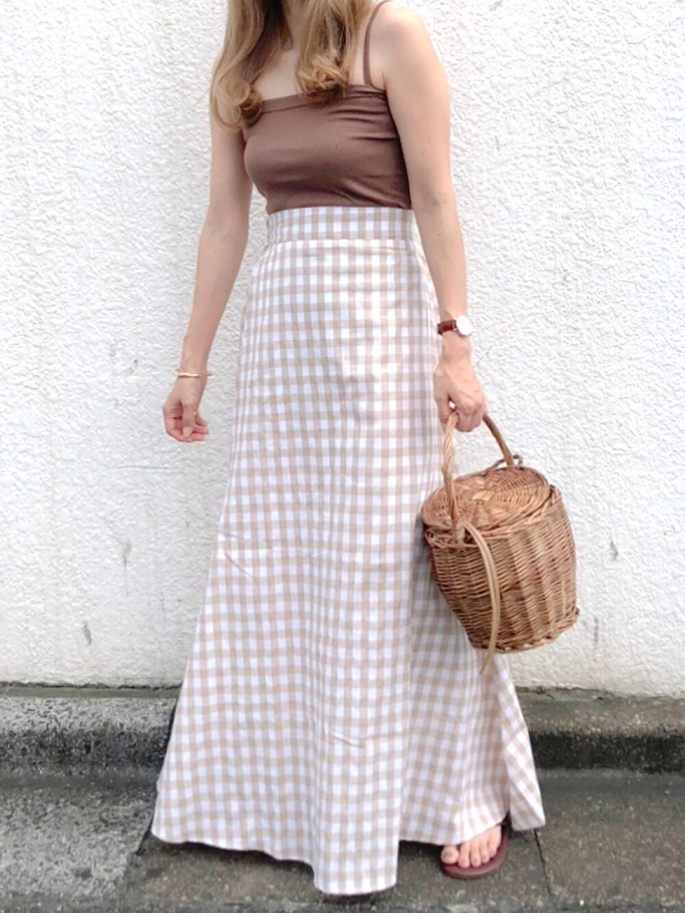 ブラウン系のキャミソール、ベージュ系のスカート、ブラウン系のビーチサンダルを着用したレディースの夏コーディネートの1枚目の写真