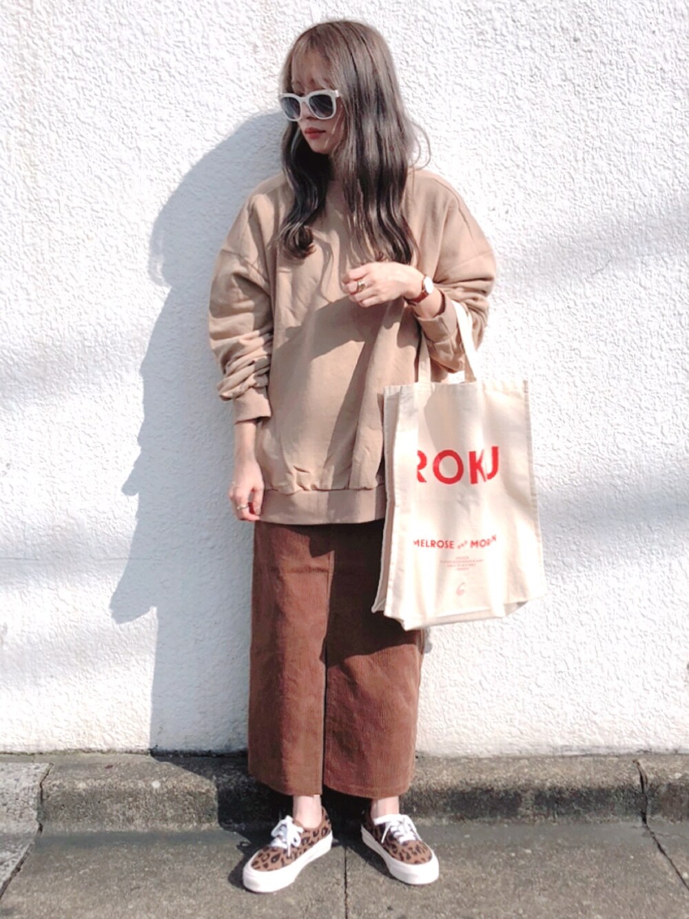 ベージュ系のスウェット、ブラウン系のスカート、ブラウン系のスニーカーを着用したレディースの秋コーディネートの1枚目の写真