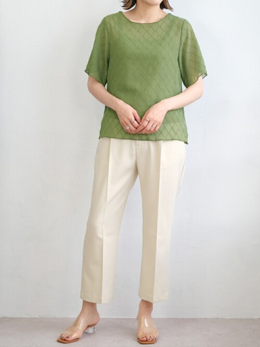 グリーン系のシャツ/ブラウス、ホワイト系のスラックスを着用したレディースの夏コーディネートの1枚目の写真