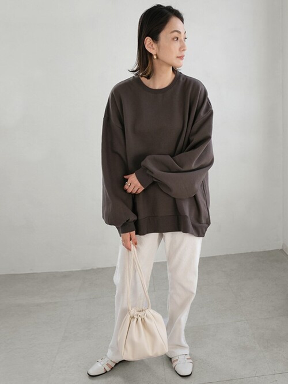 グレー系のスウェット、ホワイト系のその他パンツ、ホワイト系のショルダーバッグを着用したレディースの秋コーディネートの1枚目の写真