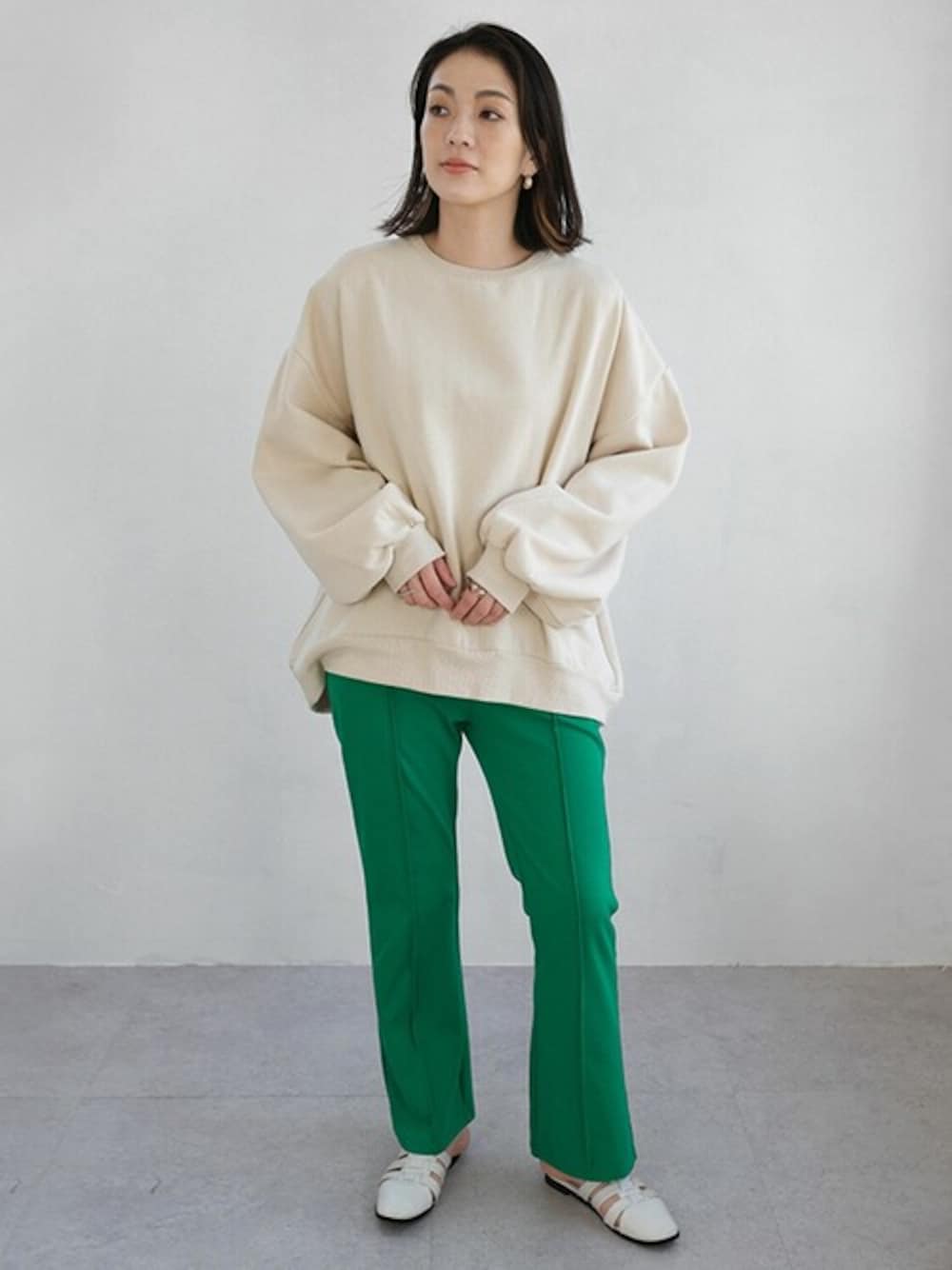 ベージュ系のスウェット、グリーン系のスラックスを着用したレディースの秋コーディネートの1枚目の写真