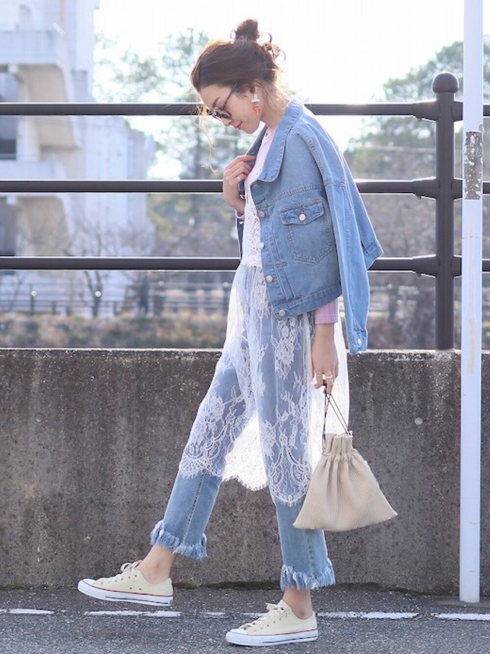 ブルー系のデニムジャケット、ホワイト系のキャミソールを着用したレディースの春コーディネートの1枚目の写真
