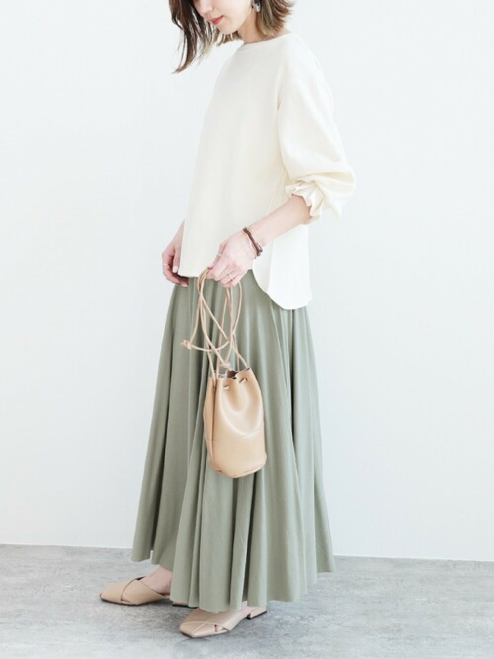 グリーン系のスカートを着用したレディースの冬コーディネートの1枚目の写真