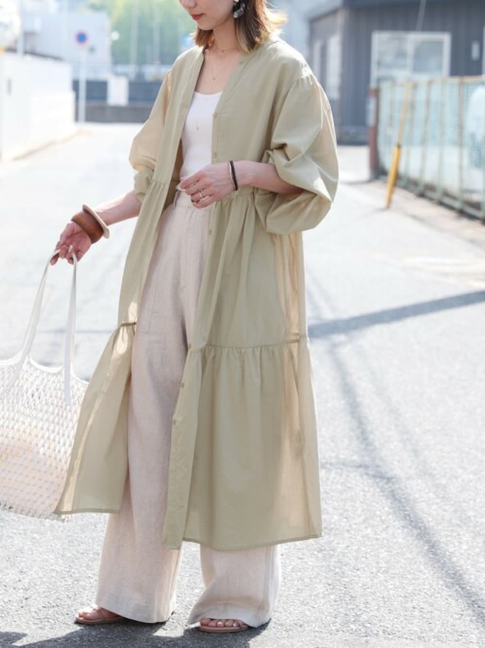 ベージュ系のワンピースを着用したレディースの春コーディネートの1枚目の写真