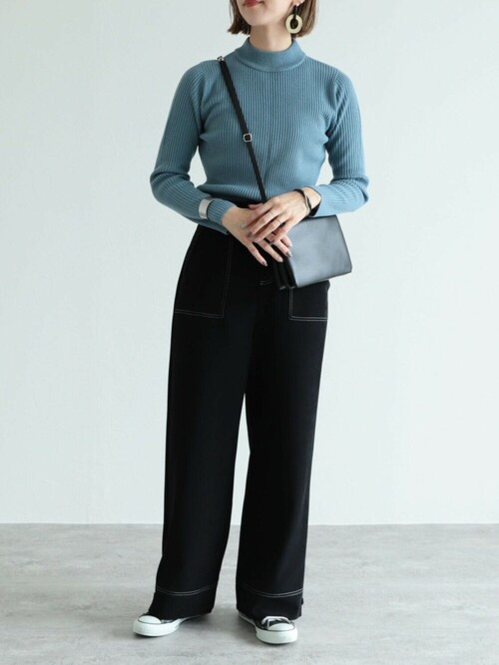 ブルー系のニット/セーター、ブラック系のその他パンツを着用したレディースの秋コーディネートの1枚目の写真