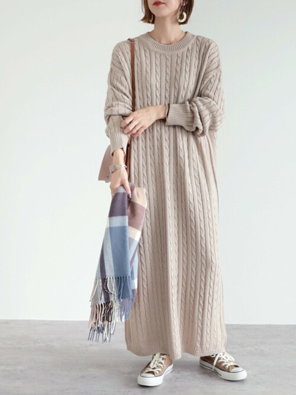 ベージュ系のワンピースを着用したレディースの秋コーディネートの1枚目の写真