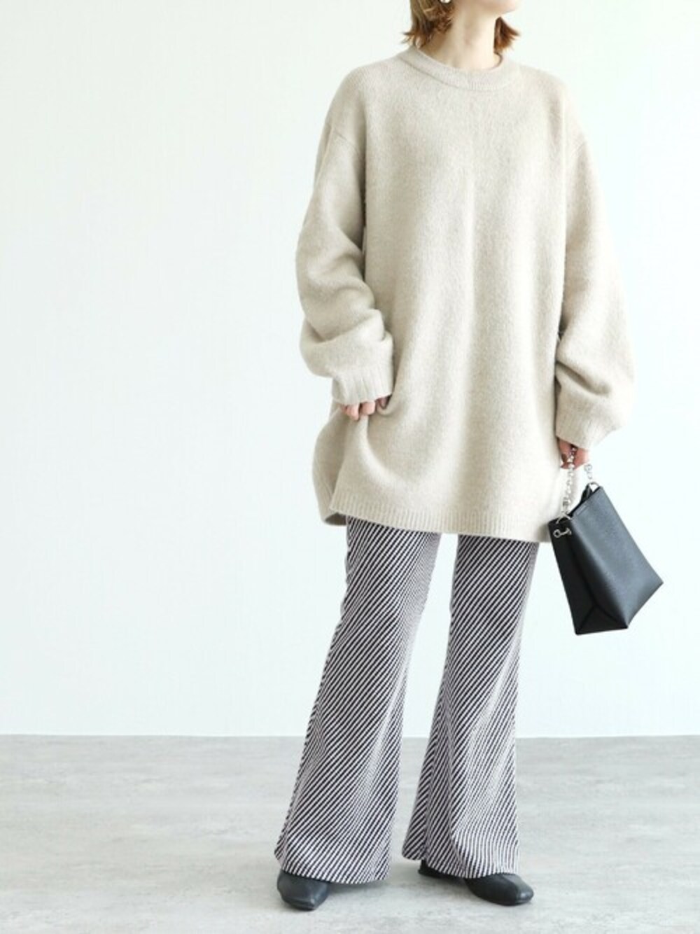 ブルー系のその他パンツ、グレー系のニット/セーターを着用したレディースの冬コーディネートの1枚目の写真