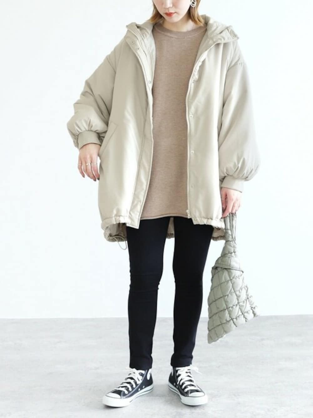 ホワイト系のダウンジャケット/コート、ベージュ系のニット/セーターを着用したレディースの冬コーディネートの1枚目の写真