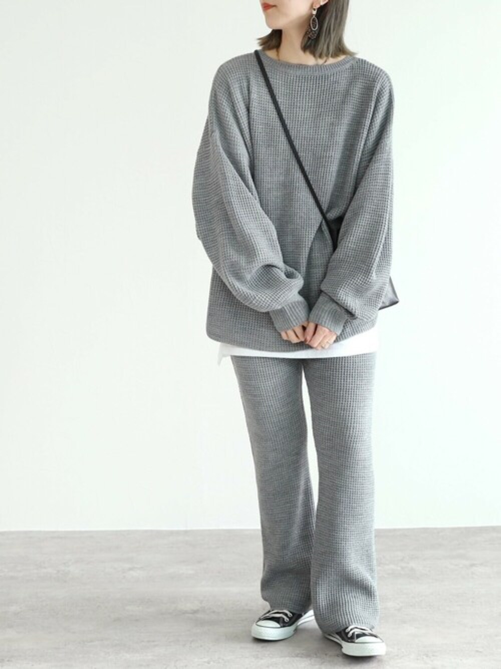 グレー系のニット/セーター、グレー系のその他パンツを着用したレディースの冬コーディネートの1枚目の写真