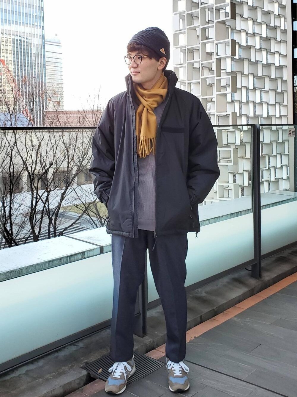 ブラック系のミリタリージャケット、パープル系のニット/セーター、グレー系のその他パンツを着用したメンズの冬コーディネートの1枚目の写真