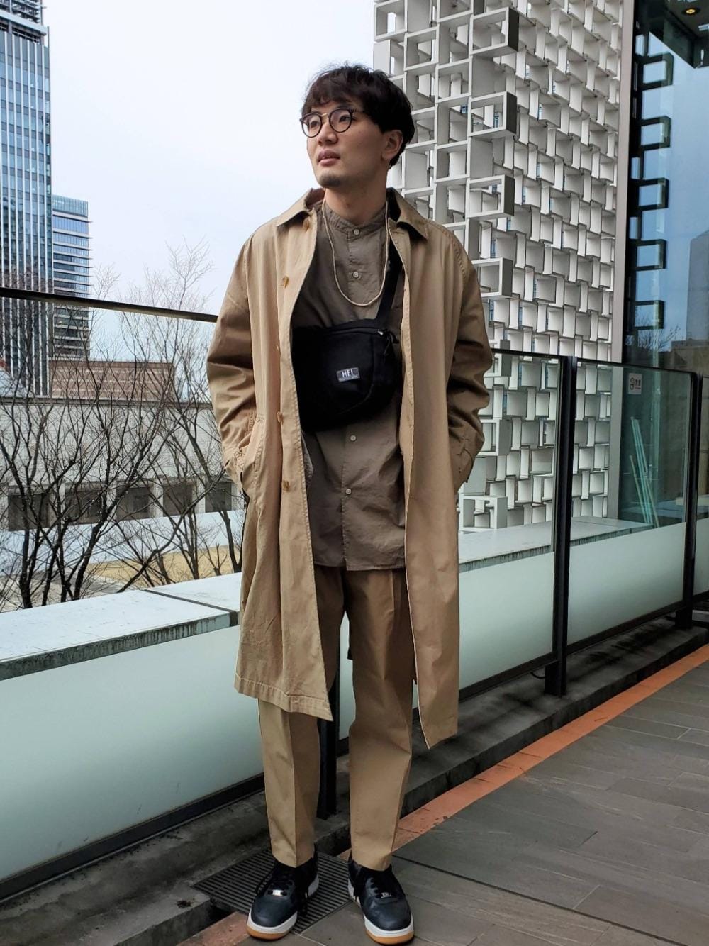 ブラック系のショルダーバッグ、ベージュ系のその他パンツ、グリーン系のシャツ/ブラウスを着用したメンズの冬コーディネートの1枚目の写真