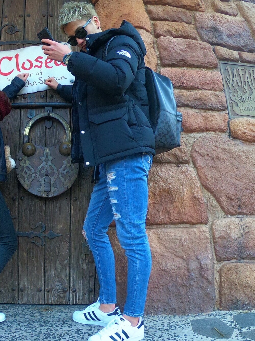 ブラック系のダウンジャケット/コート、ブルー系のデニムパンツ、ホワイト系のスニーカーを着用したメンズの冬コーディネートの1枚目の写真