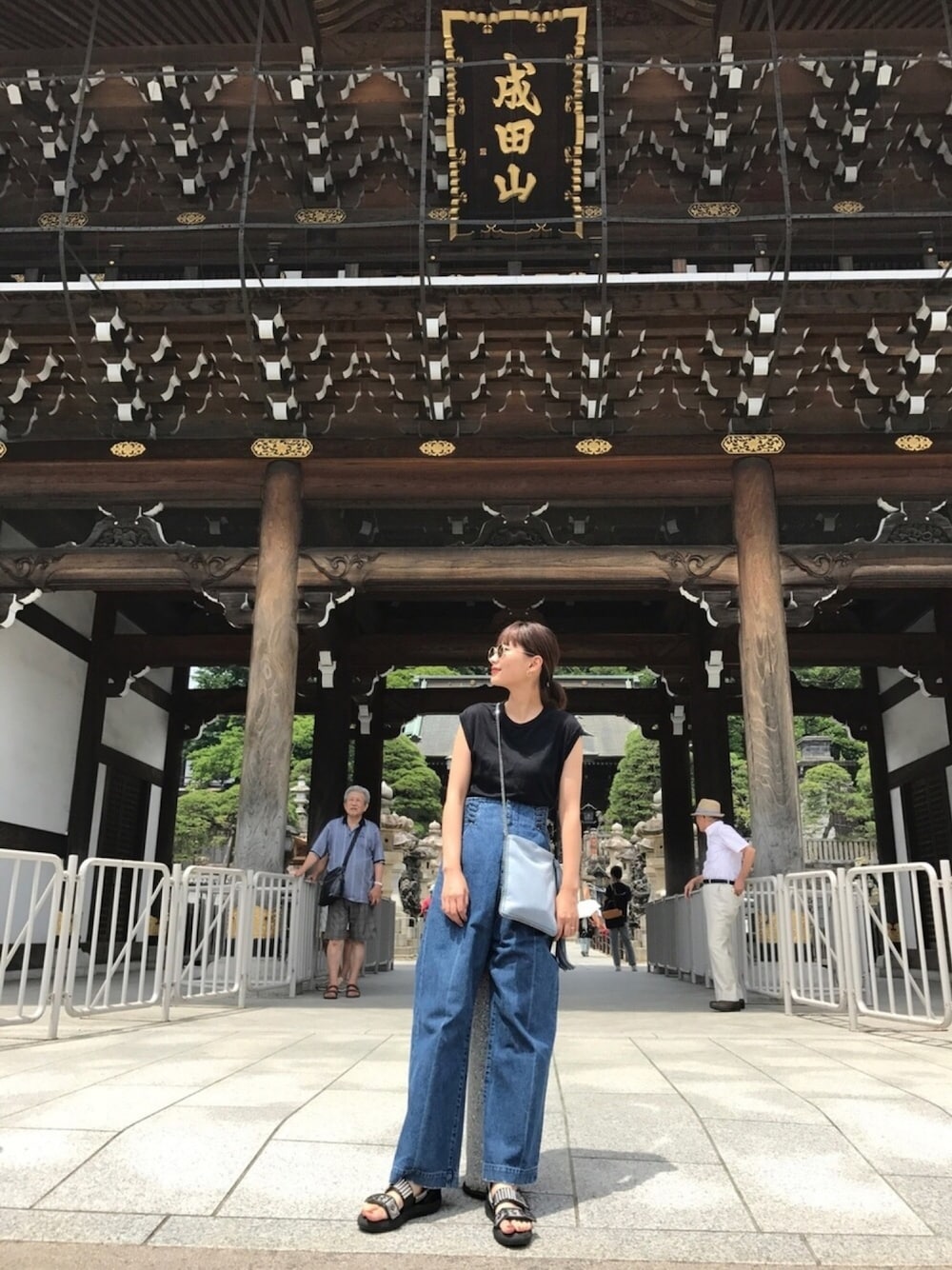 「成田山、サングラス、サンダル、カジュアル、デニム、ノースリーブ、ショルダーバッグ、夏コーデ」｜「KANEKO OPTICALのBY by KANEKO OPTICAL Steve SGLS/アイウェア MADE IN JAPAN（サングラス、ホワイト系）」を使った、潮田あかりさん（レディース・166cm）の夏コーディネートの1枚目の写真