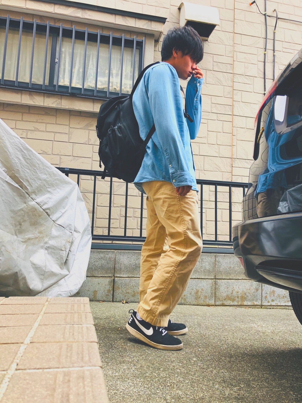「デニムシャツ、チノパン、黒スニーカー、黒リュック、LEE、TOMMY HILFIGER、NIKE、Mark Gonzales、秋のコーデ」｜「Mark Gonzalesの【Mark Gonzales/マークゴンザレス】リュック（バックパック/リュック、ブラック系）」を使った、おすかさん（メンズ・168cm）の秋コーディネートの1枚目の写真