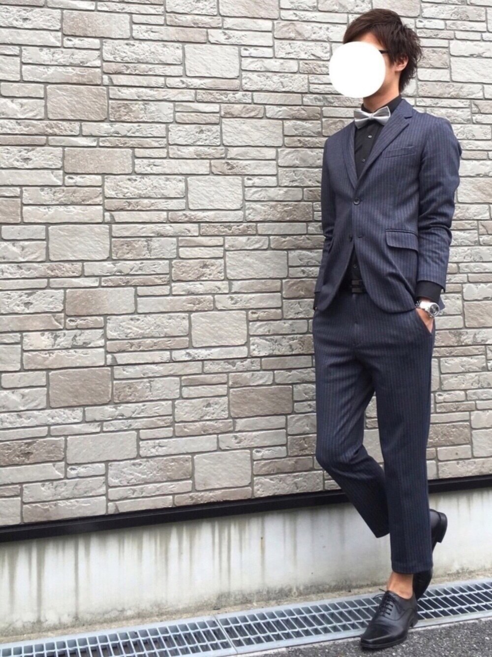 シルバー系の蝶ネクタイ、ブラック系のシャツ/ブラウス、ブルー系のパンツを着用したメンズの春コーディネートの1枚目の写真