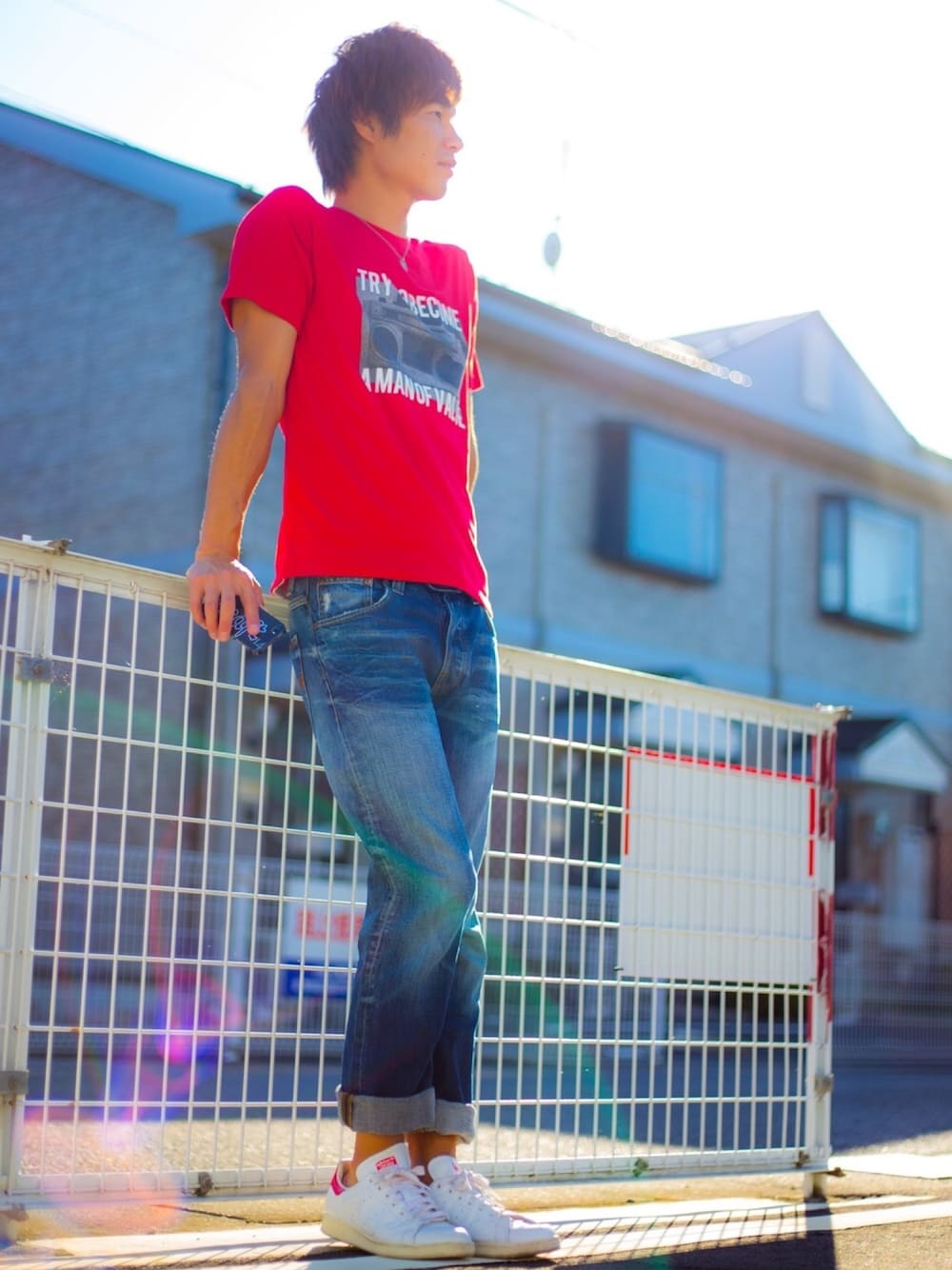 レッド系のTシャツ/カットソー、ブルー系のデニムパンツ、ホワイト系のスニーカーを着用したメンズの夏コーディネートの1枚目の写真
