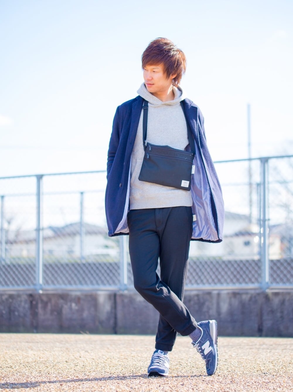 グレー系のパーカー、ブルー系のチェスターコート、ブラック系のショルダーバッグを着用したメンズの冬コーディネートの1枚目の写真