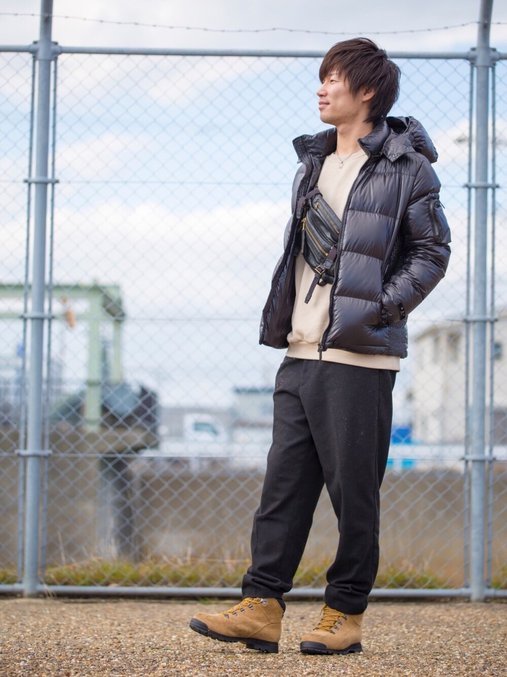 ブラック系のダウンジャケット/コート、グリーン系のスウェット、ブラック系のボディバッグ/ウエストポーチを着用したメンズの冬コーディネートの1枚目の写真