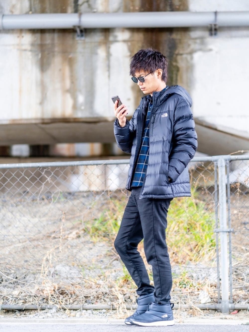 ブラック系のダウンジャケット/コート、ブルー系のシャツ/ブラウス、ブラック系のデニムパンツを着用したメンズの冬コーディネートの1枚目の写真