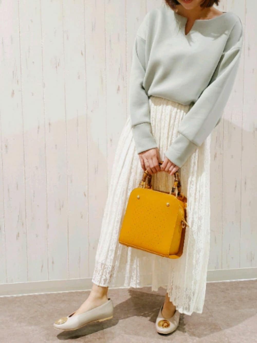 グリーン系のトップス、ホワイト系のスカート、ホワイト系のスカートを着用したレディースの冬コーディネートの1枚目の写真