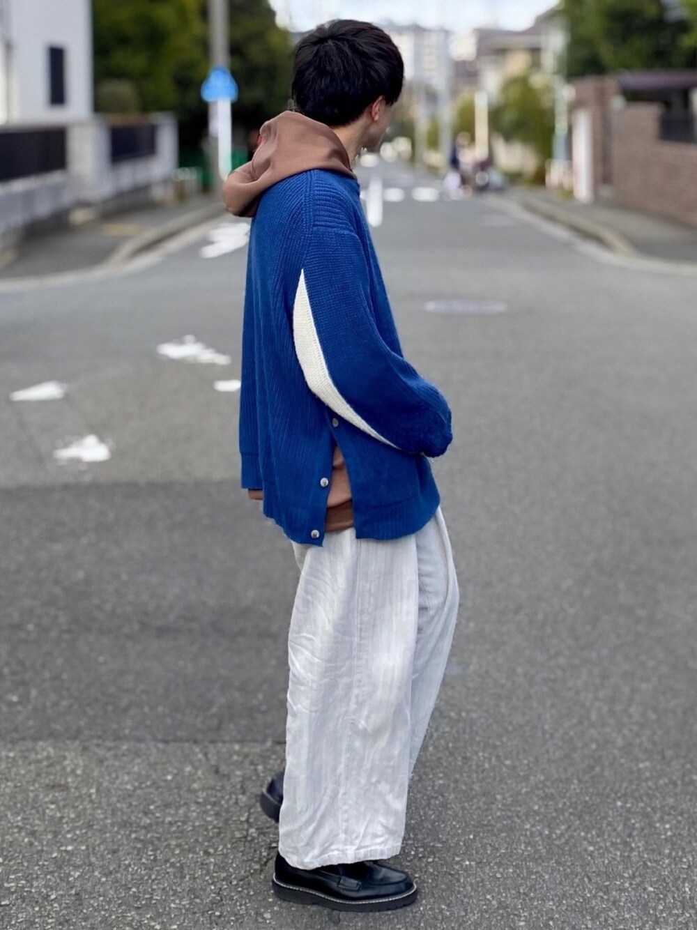 ブルー系のニット/セーター、ブラウン系のパーカー、グレー系のその他パンツを着用したメンズの春コーディネートの1枚目の写真