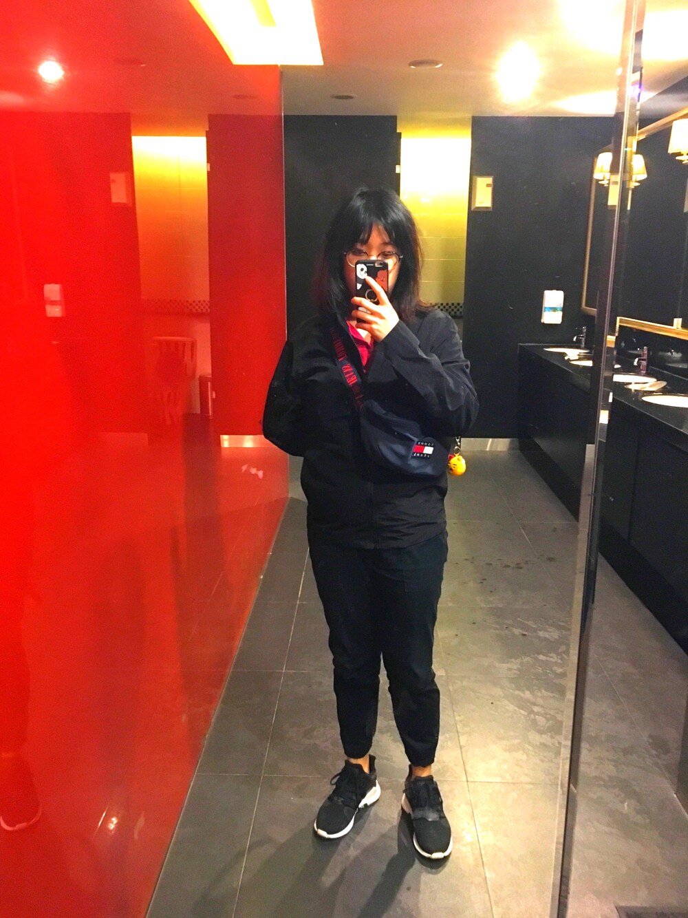 ブラック系のテーラードジャケット、レッド系のTシャツ/カットソー、ブルー系のメッセンジャーバッグを着用したレディースの冬コーディネートの1枚目の写真