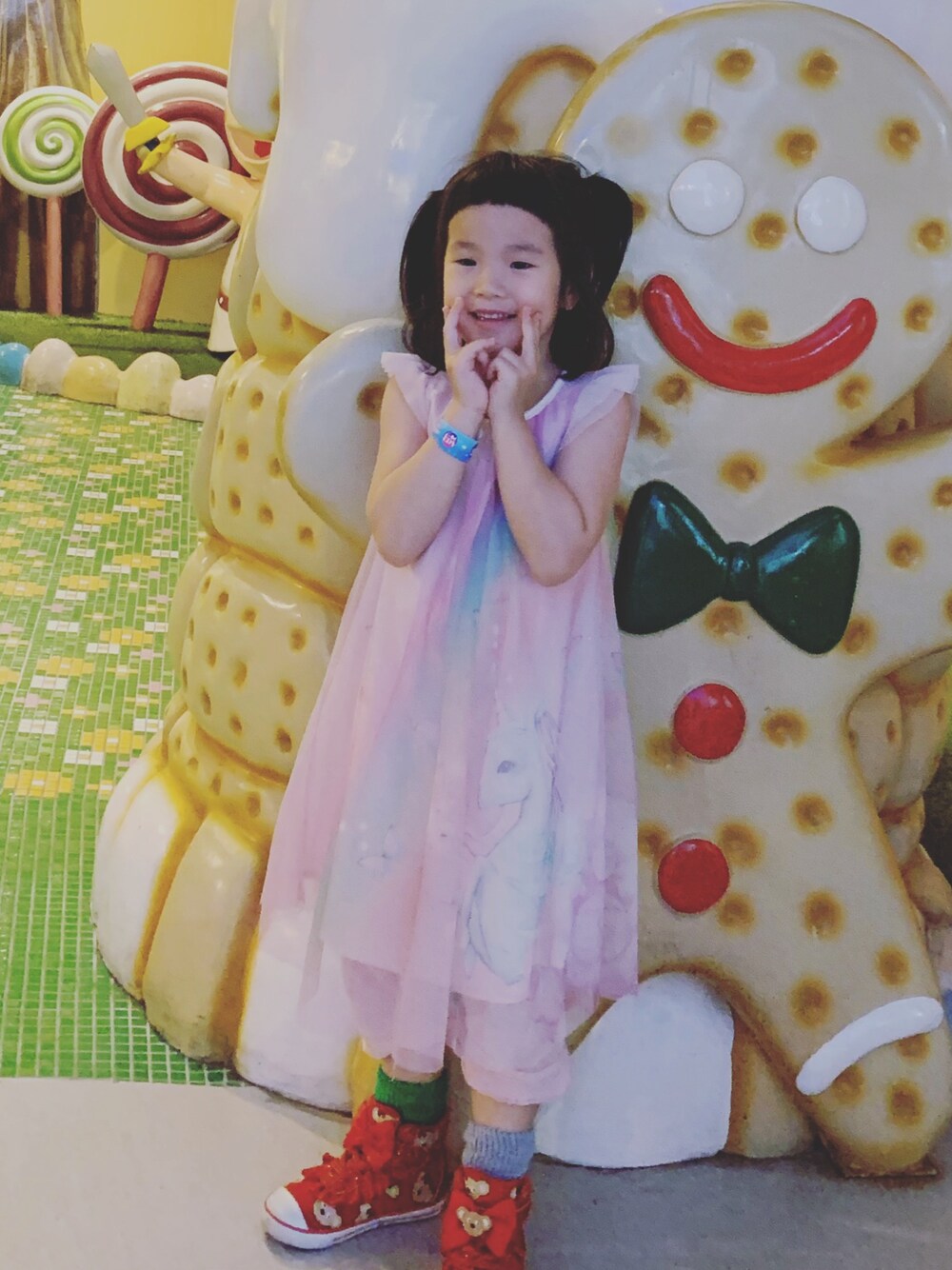 ピンク系のドレス、レッド系のスニーカーを着用したキッズの春コーディネートの1枚目の写真