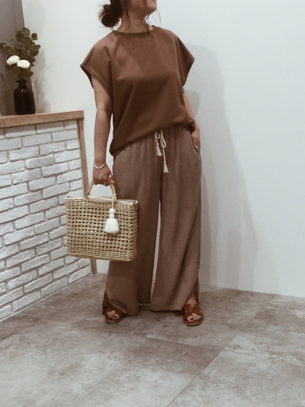 ブラウン系のTシャツ/カットソー、ベージュ系のその他パンツ、イエロー系のサンダルを着用したレディースの夏コーディネートの1枚目の写真