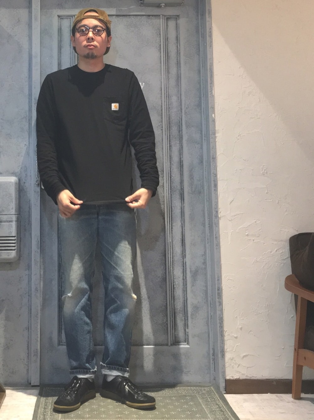 ブラック系のTシャツ/カットソー、ブラック系のスニーカー、ブルー系のデニムパンツを着用したメンズの冬コーディネートの1枚目の写真