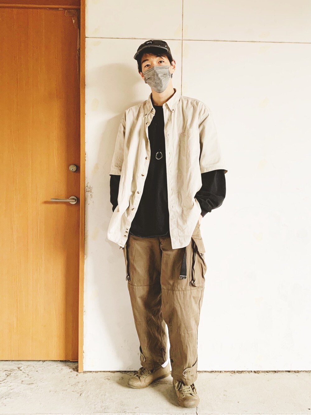ブラック系のTシャツ/カットソー、ベージュ系のシャツ/ブラウス、グリーン系のカーゴパンツを着用したメンズの春コーディネートの1枚目の写真