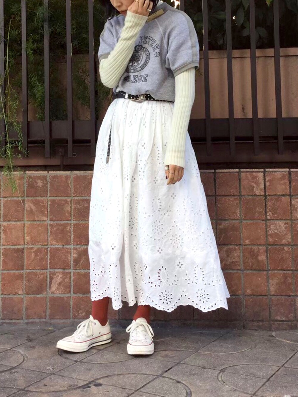 ホワイト系のスカート、グレー系のスウェット、ホワイト系のスニーカーを着用したレディースの春コーディネートの1枚目の写真