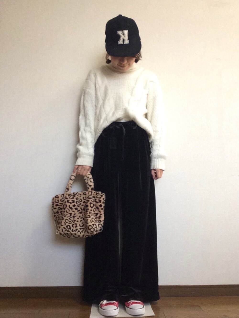 ブラック系のその他パンツ、ホワイト系のニット/セーター、レッド系のスニーカーを着用したレディースの冬コーディネートの1枚目の写真