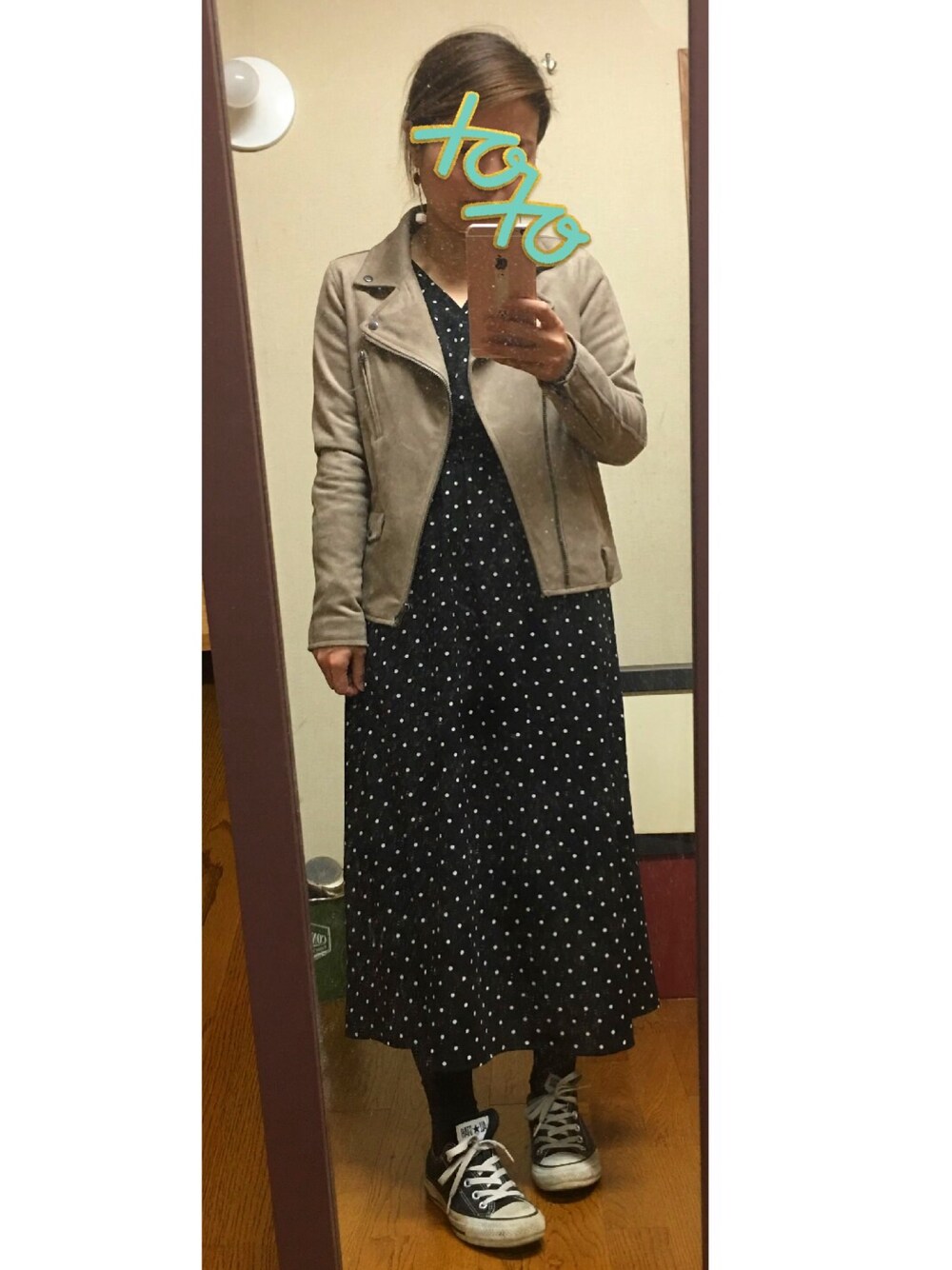 グレー系のライダースジャケット、ホワイト系のスニーカー、ブラック系のワンピースを着用したレディースの春コーディネートの1枚目の写真